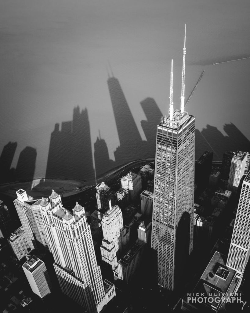 Aerial of John Hancock and its shadow cutting across Lake Michigan