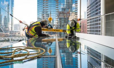 Workers prepare to install a piece of the curtain wall on Wolf Point East