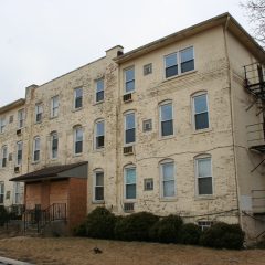 The original north building was painted white and its mansard roofs were removed to increase square footage.