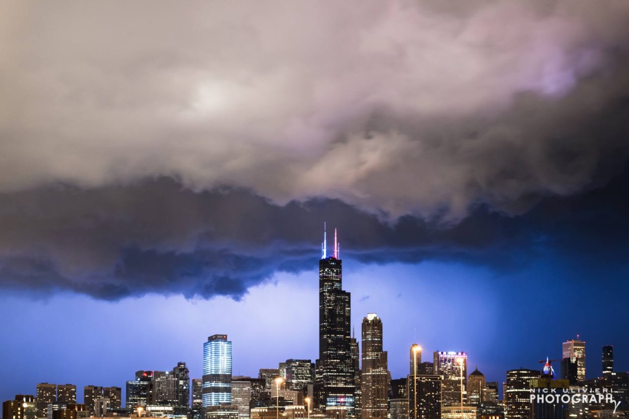 Lighting illuminates the rain falling omen the north side of the city, while low clouds slide over downtown