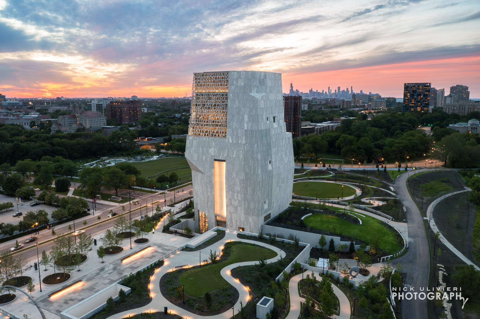 An aerial dusk view of the Obama Center library building and parkland at sunset