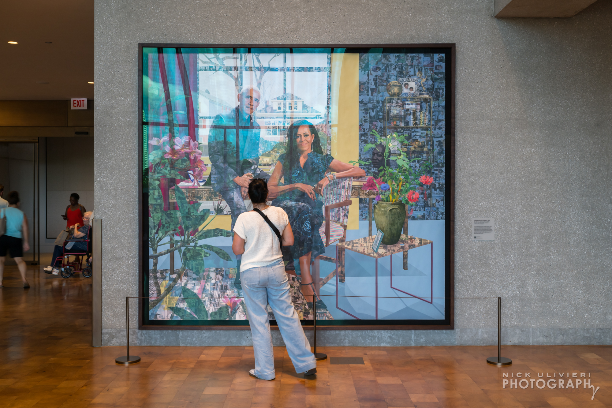 A woman closely examines the portrait of Barack and Michelle Obama by Njideka Akunyili Crosby in the Hope and Change Lobby. (public)