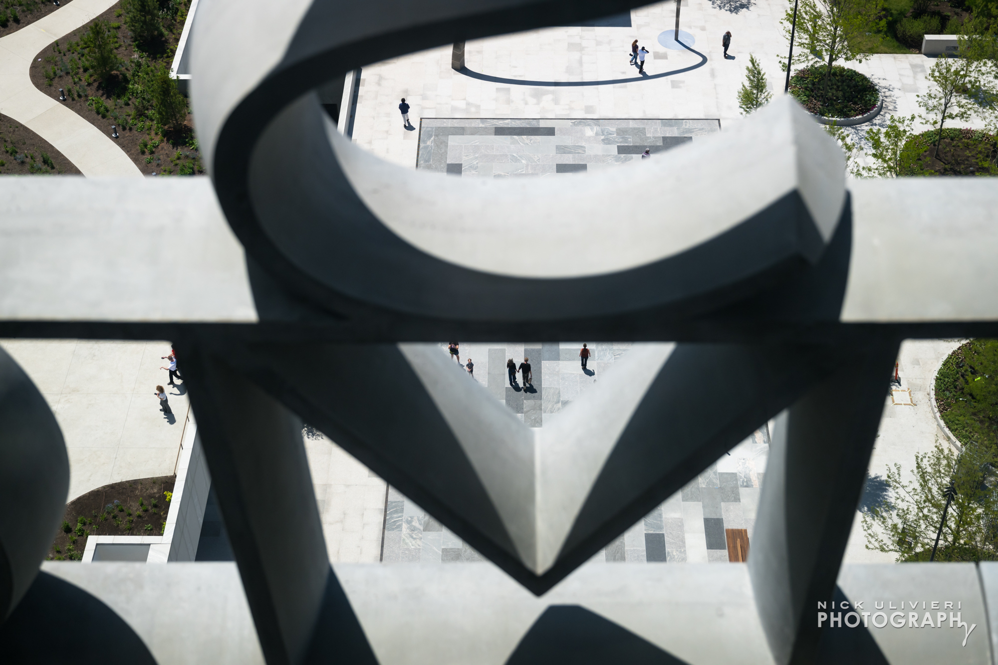 Focusing past the concrete letters from the Sky Room and onto people waling through the John Lewis Plaza.