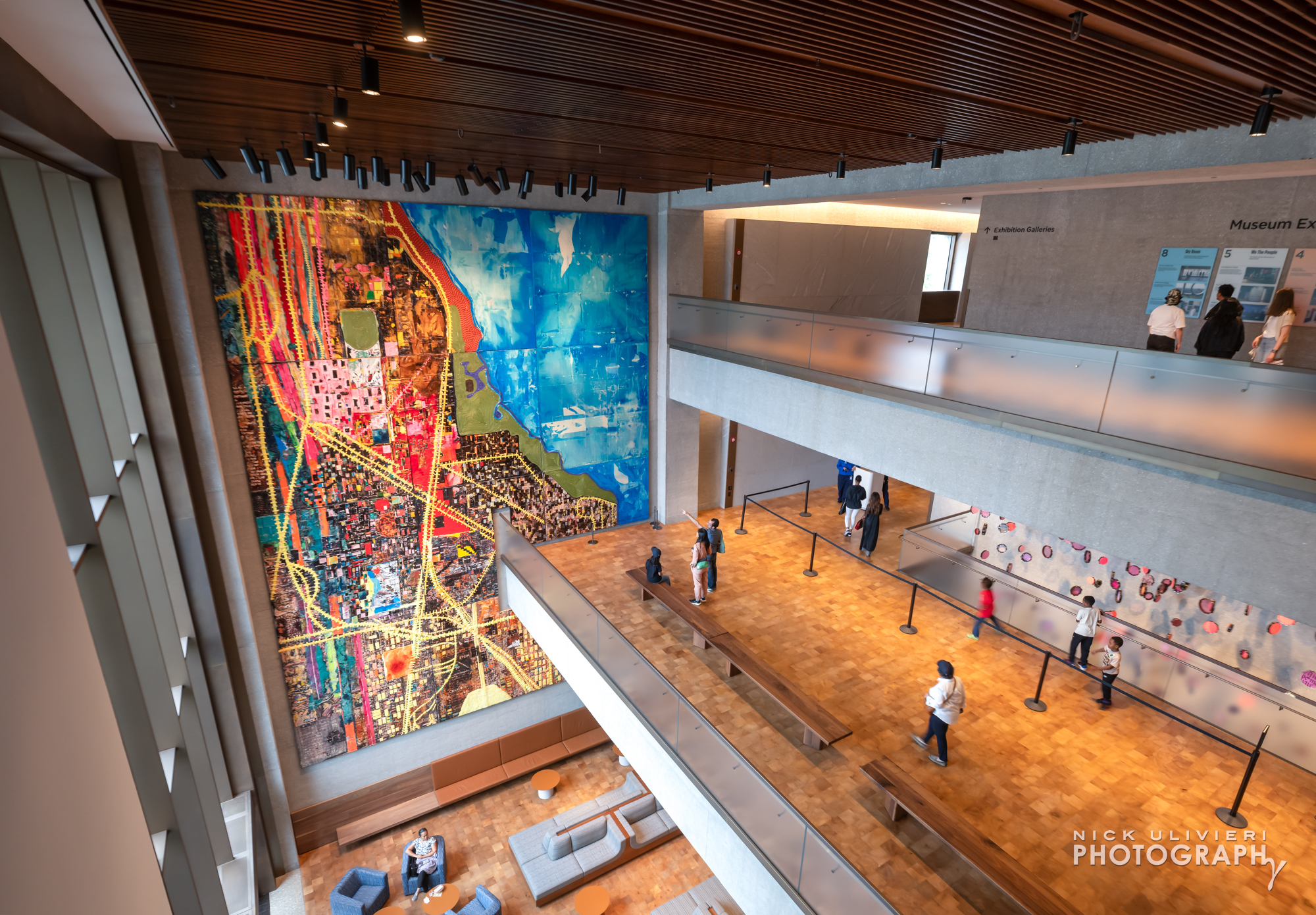 A wide-angle view of the multi-floor 'Our Story' atrium featuring 'City of the Big Shoulders'By Mark Bradford (public: lower levels)